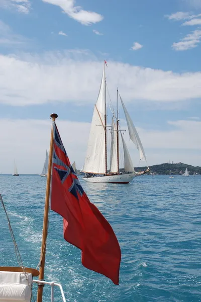 Red Ensign in front of a sailing yacht