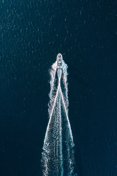 Aerial view of small boat with a trail of wash