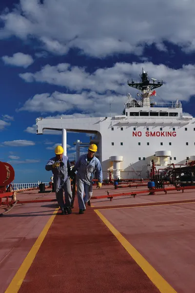 Two seafarers working on a vessel