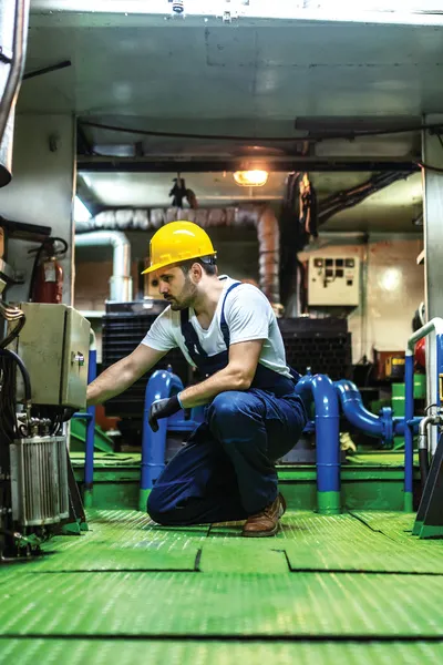 Mechanic repairing an engine inside a ship