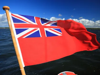 British Ensign flying at back of a yacht with blue skies and clouds