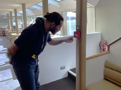 MCA Surveyor inspecting the fire alarm on a vessel