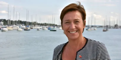 Katy Ware smiling at the camera with yachts in the background