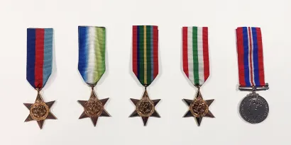 Five maritime medals laid out in a row on a white background