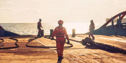 Seafarers working on a vessel at sunset