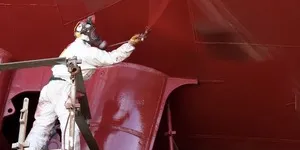 Person painting a ships hull in red