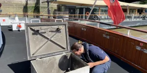 MCA Surveyor inspecting a vessel with the Red Ensign Flag in the background