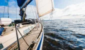Sloop rigged modern yacht with wooden teak deck on the water