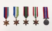 Five maritime medals laid out in a row on a white background